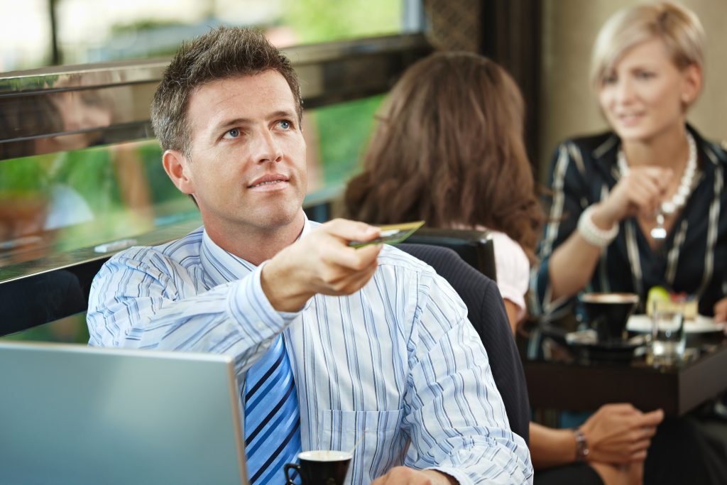 Business man paying with credit card for travel business expense.