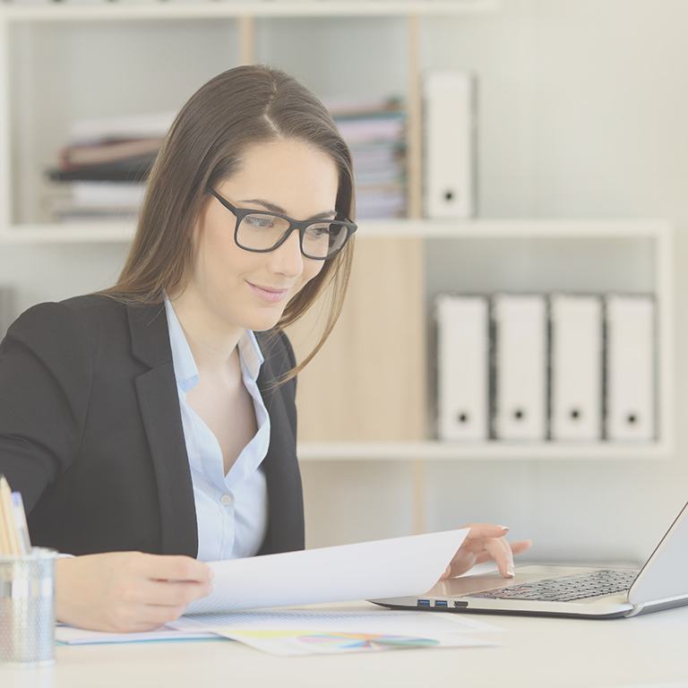 business woman at computer with reports