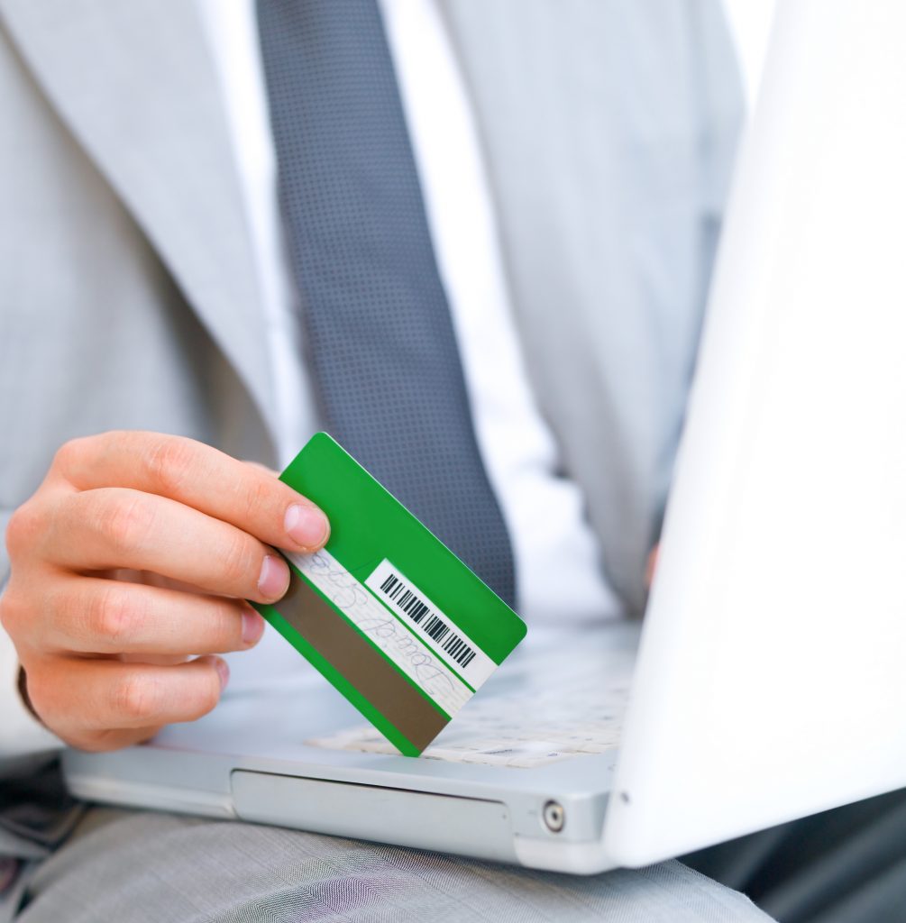 Business man with credit card sitting at computer